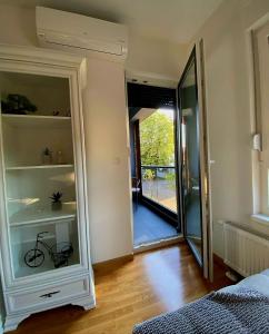 a room with a bedroom with a door to a balcony at Stan na dan Banja luka Mejdan in Hiseti