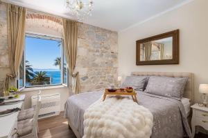 a bedroom with a bed with a table and a window at Luxury Rooms & Apartment - Main promenade, Sea & City View in Diocletian Palace Split in Split