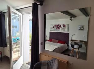 a bedroom with a bed and a mirror at Studio charmant à Valff avec jardin privé - 20 m² in Valff