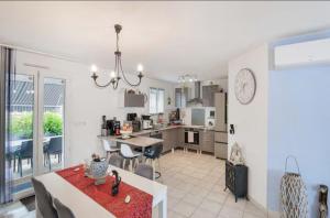 Saint-Médard-de-GuizièresにあるChambre zenのテーブルと椅子のあるキッチンとリビングルーム +7枚の写真