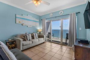 a living room with a couch and a sliding glass door at Crystal Tower 1906 by Vacation Homes Collection in Gulf Shores