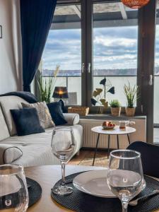 a living room with two wine glasses on a table at Apartamenty Prestige Harmony Arnikowa in Augustów
