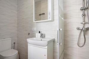 a bathroom with a sink and a toilet and a mirror at Atico Juani in Conil de la Frontera
