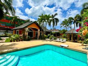 a swimming pool in front of a house at Villa Coconut Khaolak in Khao Lak