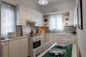 Una cocina con gabinetes blancos y una mesa y sillas. en Naoussa Breeze Residence, en Naousa