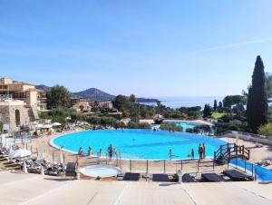une grande piscine avec des personnes debout autour de celle-ci dans l'établissement Heart of Holiday Village, near beach, WIFI, Parking, à Saint-Raphaël