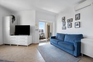 Una sala de estar con un sofá azul y un televisor. en Morning View Terrace, en Lagos