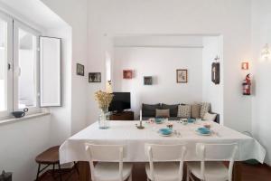 una sala da pranzo bianca con tavolo e sedie di Casa Limoeiro ad Albufeira Altre 16 foto