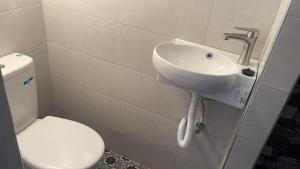 a bathroom with a white toilet and a sink at Ba Ali in Rabat