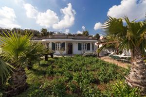 una casa con palmeras delante en La Ripostiera by BarbarHouse, en Castro di Lecce