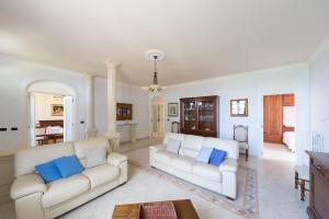 sala de estar con 2 sofás blancos y almohadas azules en La Ripostiera by BarbarHouse, en Castro di Lecce