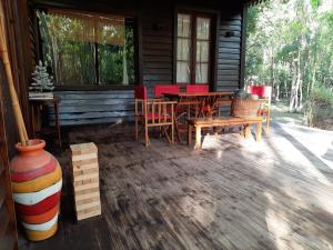 eine Veranda eines Blockhauses mit einem Tisch und Stühlen in der Unterkunft Ramallo Lote 58 Estancia Estrella Federal in Ramallo