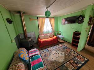 a living room with a couch and a bedroom with green walls at CasaNancy in Panguipulli