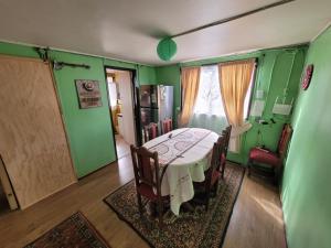 a dining room with a table and chairs and green walls at CasaNancy in Panguipulli