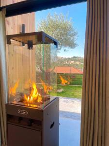 una griglia con un fuoco acceso davanti a una finestra di Mit Warde Cabin a Batroûn