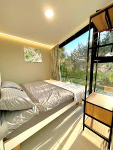 una camera da letto con un letto e una grande finestra di Mit Warde Cabin a Batroûn