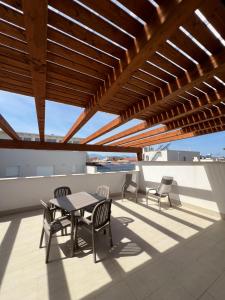 eine Terrasse mit einem Tisch und Stühlen auf dem Dach in der Unterkunft Appartamenti Via Meli in Balestrate