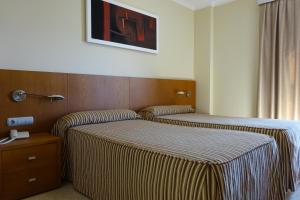 Habitación de hotel con 2 camas y una foto en la pared en Nou Avenida, en Gata de Gorgos