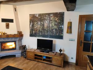 a living room with a tv and a fireplace at Casa Erro Zapatainea - Refugio y Naturaleza in Erro