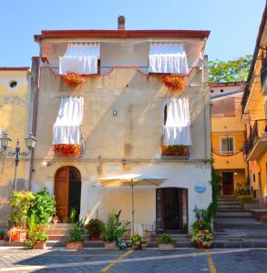 a building with two balconies and an umbrella on a street at Donna Alda Affittacamere in Villammare