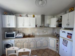 a kitchen with white cabinets and a microwave at Maison charmante près du lac d'Esparron, 2 chambres, parking - FR-1-822-10 in Esparron-de-Verdon +5 photos