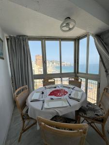 een eetkamer met een tafel en uitzicht op de oceaan bij Iberia Apartment in Benidorm