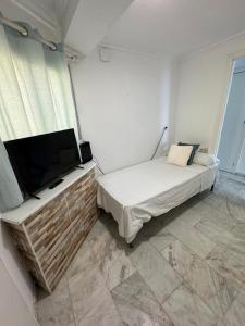 een slaapkamer met een bed en een flatscreen-tv bij Iberia Apartment in Benidorm