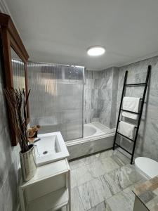 een badkamer met een wastafel en een ligbad bij Iberia Apartment in Benidorm