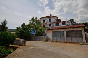 a house with a garage in front of it at Apartment Elza in Ičići