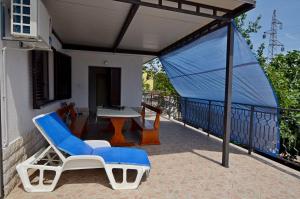 a blue and white chair and a table on a balcony at Apartment Elza in Ičići
