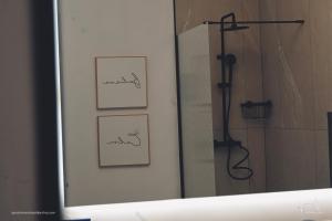 a bathroom mirror with three pictures and a shower at Apartamentos Al-Karika in Coria +89 photos