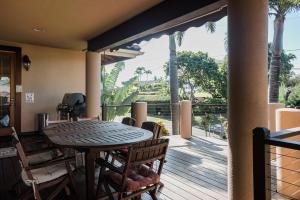 a patio with a table and chairs on a deck at Ocean view, Beautiful sunrise, Private pool, Walk to beaches in Koloa