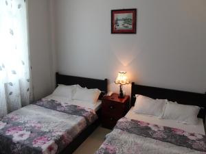 a bedroom with two beds and a lamp on a night stand at Sea Stars Hotel in Rach Gia +28 photos