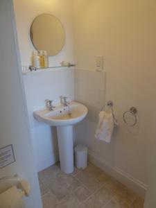 a bathroom with a sink and a mirror at Lower Tresmorn Farmhouse in Crackington Haven