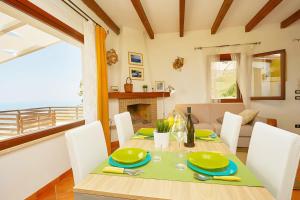 una sala da pranzo con tavolo, sedie e camino di Villetta Bonifato con Vista Mozzafiato ad Alcamo