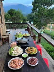 una tavola ricoperta di piatti di cibo su un ponte di Khu Nghỉ Dưỡng Lộc Nam Hill Bảo Lộc a Pro Lach (2)