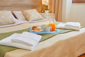 un letto con un vassoio di cibo e bevande. di Villetta Bonifato con Vista Mozzafiato ad Alcamo