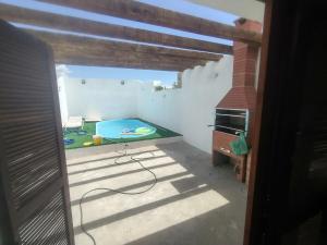 a room with a patio with a table and a pool at Casa praia in Pelotas