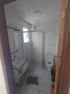 a bathroom with a toilet and a shower and a sink at Casa praia in Pelotas