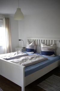 a bed with blue sheets and pillows in a room at Ferienwohnung am Brunnen in Titisee-Neustadt