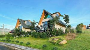 una casa seduta in cima a un campo verde di Khu Nghỉ Dưỡng Lộc Nam Hill Bảo Lộc a Pro Lach (2) Altre 34 foto