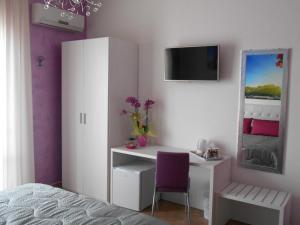 a bedroom with a desk with a purple chair at Capital Bed Porto Cesareo in Porto Cesareo