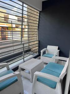 a balcony with chairs and tables and a window at Casa amueblada en San Cristóbal in San Cristóbal
