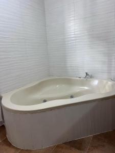 a white bath tub in a bathroom with white walls at Casa amueblada en San Cristóbal in San Cristóbal
