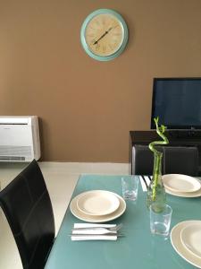 a table with plates and a clock on the wall at Elysium in Bucharest