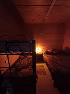 a dark room with two beds and a lamp at Cabaña Del Jardín San Pedro De Colalao in San Pedro de Colalao +3 photos