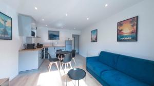 a living room with a blue couch and a kitchen at Cocooning Apartment - Paris - Orly aéroport 10 min in Orly