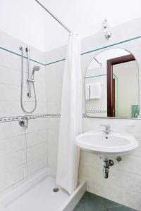 a white bathroom with a sink and a mirror at Da Giorgio in Capri