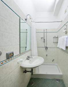 a white bathroom with a sink and a bath tub at Da Giorgio in Capri