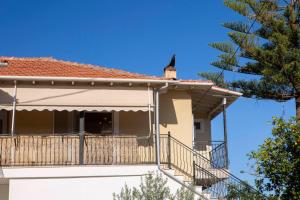a house with a balcony and a bird on the roof at Lemon House Lefkada in Lefkada